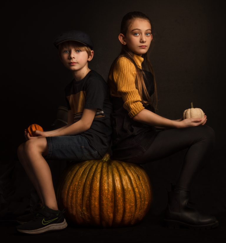 kids sat on a giant pumpkin